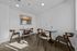 Chic and modern seating area with stylish wooden chairs and round tables, complemented by elegant wall art under bright lighting.
