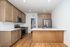Modern kitchen with sleek wood cabinetry, stainless steel appliances, and elegant white countertops.