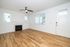 Bright and inviting living space with elegant fireplace, modern ceiling fan, and sleek hardwood floors.