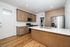 Contemporary kitchen with sleek stainless steel appliances, elegant wooden cabinetry, and a spacious island with quartz countertop.
