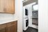 Chic laundry space featuring modern stacked washer and dryer with elegant cabinetry and a bright door leading outside.