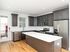 Modern kitchen with sleek gray cabinetry, stainless steel appliances, and a spacious white countertop island.