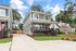 Charming two-story house with modern gray siding, red doors, and lush green lawn, offering a welcoming home exterior.