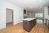 Bright and airy open-concept kitchen with modern island, sleek cabinetry, and spacious living area with large windows and wood flooring.