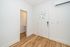 Bright entrance with a sleek white door and elegant hardwood floors, featuring modern wall-mounted air conditioning.