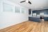 Bright modern kitchen with sleek blue cabinets, stainless steel appliances, and elegant wood flooring.