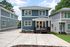 Charming two-story blue house with modern siding, spacious driveway, and inviting front porch in a serene suburban neighborhood.