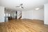 Elegant open-plan living space featuring sleek hardwood floors, modern lighting, and access to a stylish kitchen island.