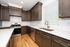 Modern kitchen with elegant dark wood cabinetry, sleek white countertops, stainless steel appliances, and chic tile backsplash.