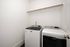 Spacious laundry room featuring modern Maytag washer and dryer with ample hanging space.