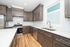 Modern kitchen with sleek dark wood cabinets, stainless steel appliances, and elegant white countertops, offering a blend of style and functionality.
