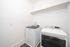 Modern laundry room equipped with sleek, high-efficiency washer and dryer, complemented by elegant shelving above.