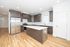 Modern kitchen with sleek dark wood cabinetry, stainless steel appliances, and a spacious island, featuring elegant hardwood floors and ample natural light.