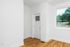 Charming entryway with elegant white door and large window inviting natural light onto beautiful hardwood floors.