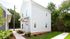 Charming two-story home with pristine white siding and well-maintained landscaping, nestled in a serene neighborhood setting.