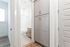 Bright and inviting bathroom entrance with elegant gray cabinetry and modern tile flooring.