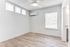 Bright and airy room with modern wood flooring, energy-efficient ceiling fan, and large windows ensuring ample natural light.