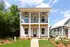 Charming two-story home with modern design, featuring a spacious balcony, double-height columns, and lush landscaping.