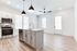 Modern kitchen with sleek cabinetry, stainless steel appliances, and stylish pendant lighting over a central island in a bright open-concept space.