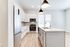 Bright and modern kitchen with sleek stainless steel appliances, elegant white cabinetry, and chic pendant lighting.