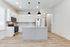 Modern kitchen with sleek white cabinetry, stainless steel appliances, and a stylish island under elegant pendant lighting.