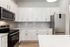 Modern kitchen with sleek stainless steel appliances, elegant white cabinetry, and a polished marble countertop, perfect for gourmet cooking and entertaining.