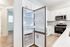 Sleek modern kitchen featuring a stainless steel fridge, elegant cabinetry, and spacious countertops.
