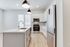 Modern kitchen with sleek white cabinetry, stainless steel appliances, and elegant pendant lighting, creating a stylish and inviting space.