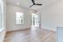 Bright and airy room with elegant wood flooring, ceiling fan, and inviting door opening to a scenic balcony view.