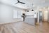 Elegant open-plan kitchen and living area featuring modern appliances, sleek cabinetry, and stylish lighting in a bright, spacious room.
