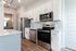 Modern kitchen design featuring sleek stainless steel appliances, elegant white cabinetry, and luxurious wooden flooring.