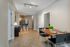 Inviting open-concept dining area with modern decor, featuring a sleek wooden table, cozy seating, and a view into a stylish kitchen with bar seating.