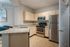 Modern kitchen with sleek granite countertops, stainless steel appliances, and warm wood cabinetry offering a spacious and inviting cooking area.