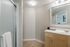 Contemporary bathroom featuring a sleek vanity with a large mirror, modern lighting, and a refreshing glass-enclosed shower.