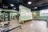 Modern fitness center with state-of-the-art equipment, motivational wall art, and natural light streaming in through large windows.