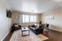 Inviting living room with sleek hardwood floors, modern furnishings, and ample natural light, creating a cozy ambiance.