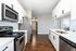 Modern kitchen with sleek stainless steel appliances, elegant white cabinetry, and warm hardwood floors.