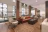 Modern open-concept lounge area with natural light, stylish seating, and lush greenery accents.