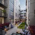 Modern apartment courtyard featuring elegant seating, lush green spaces, and ambient lighting for a serene urban experience.