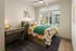 Bright, stylish bedroom with colorful floral bedding, modern desk, and large window offering plenty of natural light.