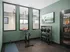 Modern home gym with a stationary bike, wall-mounted TV, and sleek storage for exercise equipment.