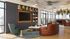 Modern and inviting living space with elegant furnishings, featuring a large TV, stylish bookshelves, and expansive windows offering scenic views.
