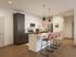 Modern kitchen with sleek cabinetry, stainless steel appliances, and stylish bar seating in a bright, open space.