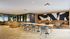 Modern communal space with chic plaid chairs, cozy leather seating, and stylish decor against an artistic wall backdrop.