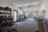 Modern fitness center featuring state-of-the-art equipment, including treadmills, exercise bikes, and weight benches, with a view of the pool.