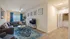 Modern living room featuring a stylish sectional sofa, vibrant blue curtains, and a sleek wall-mounted TV, perfect for relaxation and entertainment.
