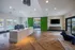 Modern apartment lobby with sleek wood flooring, vibrant green barn doors, and large windows offering poolside views.