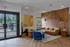 Modern lounge area with stylish wooden accent wall, plush seating, and natural light pouring through large windows.