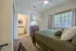 Cozy bedroom with plush carpet, natural light streaming through large windows, and an en-suite bathroom for added convenience.
