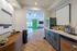 Inviting apartment kitchen with modern cabinetry, sleek countertops, and charming wood flooring leading to a bright living area with green barn doors.